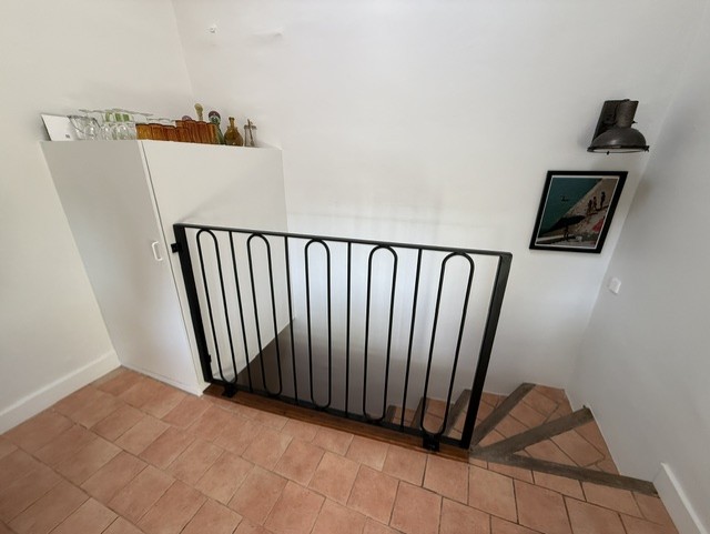 Garde-corps noir à motifs arrondis sur un palier d’escalier