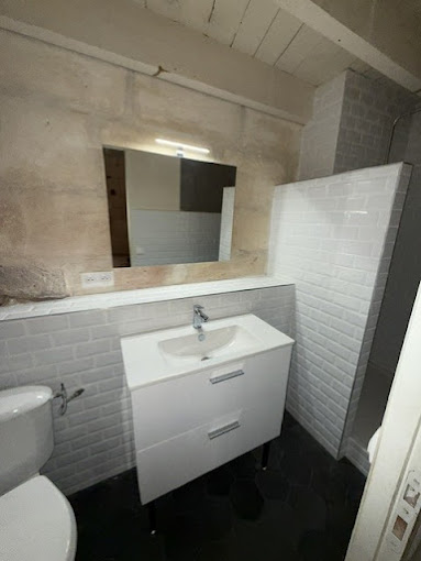 Salle de bains avec meuble vasque, miroir et revêtements muraux